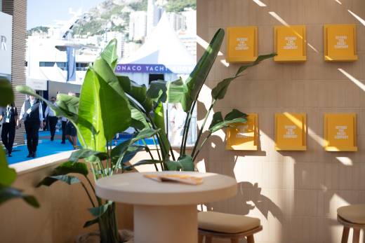Sunlight streams across a stylish display of "Beyond the Yacht Company" brochures at the Monaco Yacht Show.