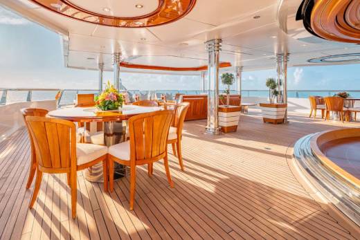 A luxurious and spacious outdoor deck area with wooden floors, comfortable seating, and a scenic view of the surrounding landscape.