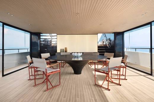 This luxurious yacht dining area offers breathtaking ocean views through floor-to-ceiling windows.