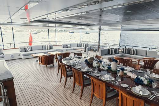 An elegant yacht deck sets the scene for a luxurious al fresco dining experience with a beautifully decorated table.