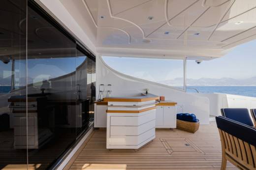 Enjoy refreshing drinks at the sleek bar on this luxurious yacht's expansive deck overlooking the azure sea.