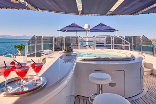 Enjoy refreshing cocktails by the jacuzzi on this luxurious yacht deck with stunning ocean views.