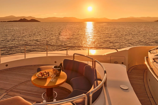 Golden hour paints the sea and sky as a luxurious yacht awaits with chilled champagne and a delightful spread.