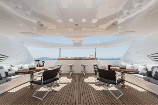 Relax in style on this luxurious yacht's deck, complete with a bar, comfortable seating, and stunning ocean views.