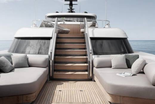 A luxurious yacht with a sleek, modern design, featuring a spacious deck with comfortable seating areas and a set of stairs leading to the interior.
