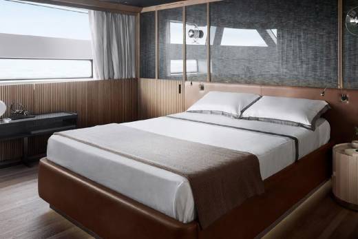 A cozy and modern bedroom with a large bed, wooden paneling, and a window providing natural light.