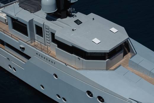 A large gray ship with a distinctive octagonal superstructure and various openings and features on its exterior.