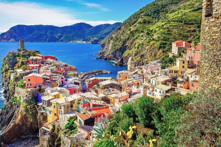 Colorful buildings cling to dramatic cliffs overlooking the azure waters of the Italian Riviera.