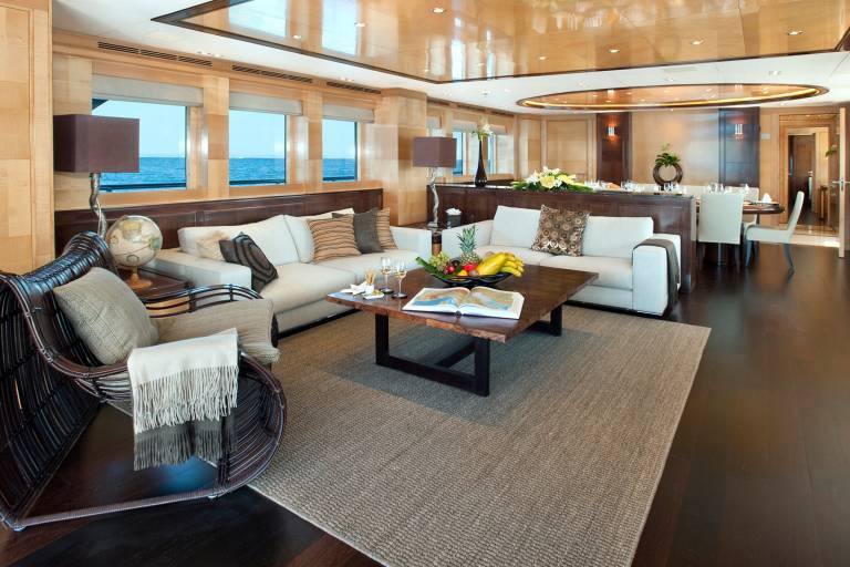 Luxurious yacht interiors offer stunning ocean views from plush seating areas and a formal dining space.