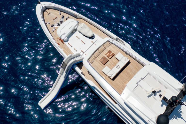 A luxurious yacht with a slide into the sparkling blue ocean offers the ultimate vacation experience.