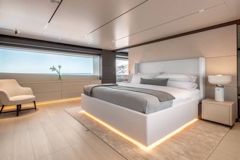 Luxurious yacht bedroom offers serene ocean views and ambient lighting for ultimate relaxation.