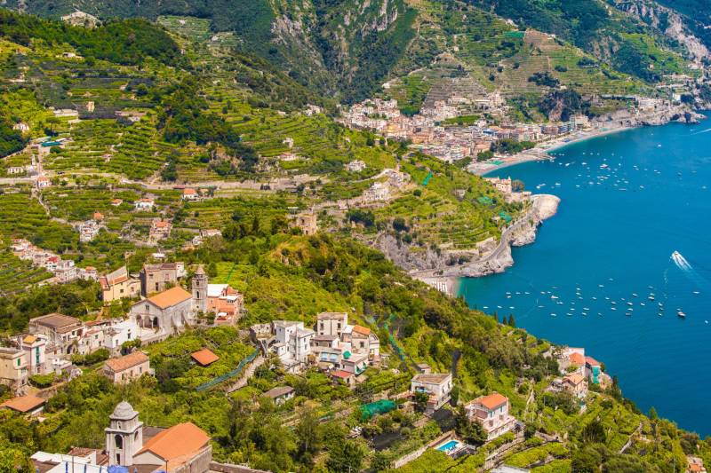 Terraced hillsides cascade down to the sparkling blue waters of the Amalfi Coast, dotted with picturesque villages.