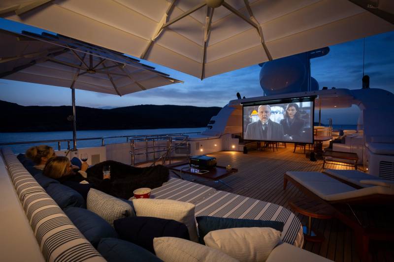 Enjoy an intimate outdoor movie night under the stars on this luxurious yacht deck.