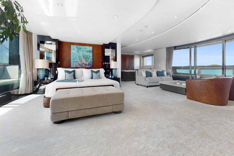 Luxurious yacht master suite offers stunning ocean views and elegant comfort with plush furnishings and contemporary art.