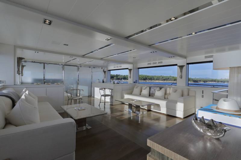Luxurious yacht interiors offer stunning views of the Mediterranean coastline from expansive windows.