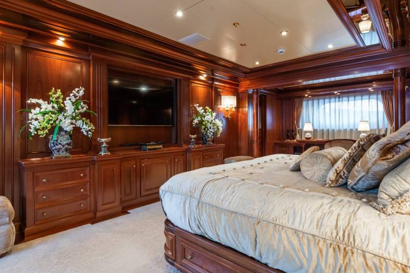 Luxurious cherry wood paneling and plush furnishings create an opulent master suite aboard this elegant yacht.