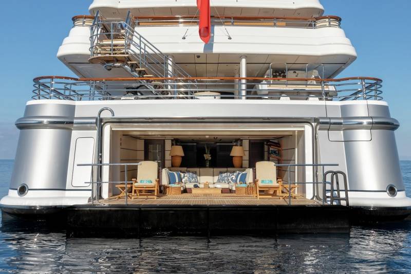 The luxurious aft deck of a superyacht offers a serene lounge area with comfortable seating and stunning ocean views.