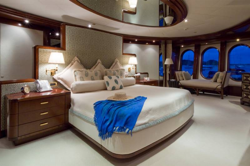 Luxurious yacht bedroom offers a serene retreat with ocean views and elegant furnishings.
