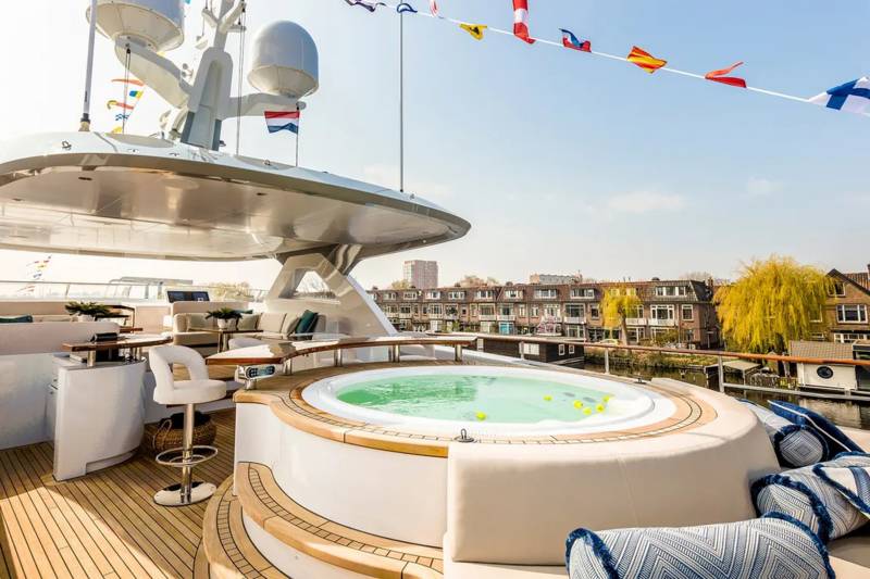 Relax in the luxurious onboard jacuzzi while enjoying picturesque canal views from this stunning yacht deck.