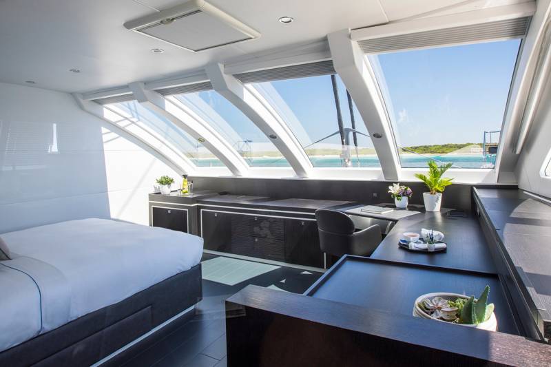 Luxurious yacht cabin offers a serene retreat with expansive windows framing a breathtaking ocean vista.