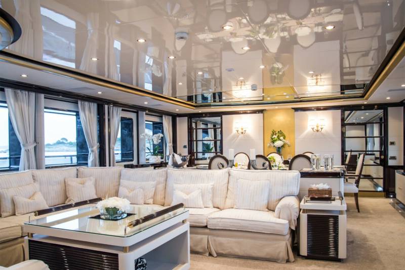 Luxurious yacht interiors feature plush seating and elegant dining spaces with scenic ocean views.
