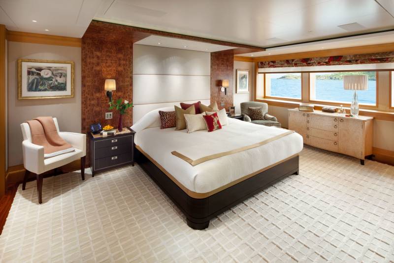 Luxurious yacht stateroom offers stunning ocean views and elegant furnishings for a serene retreat.