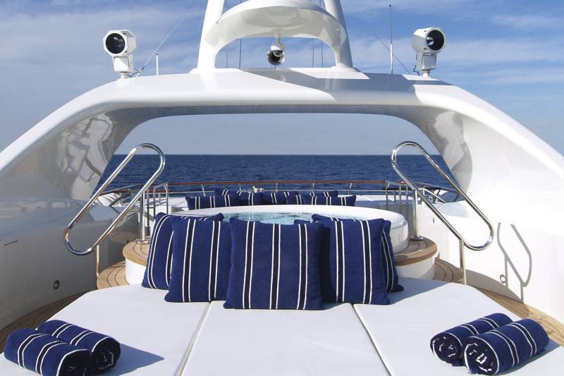 Relax in style on the deck of this luxurious yacht, complete with a jacuzzi and plush seating.
