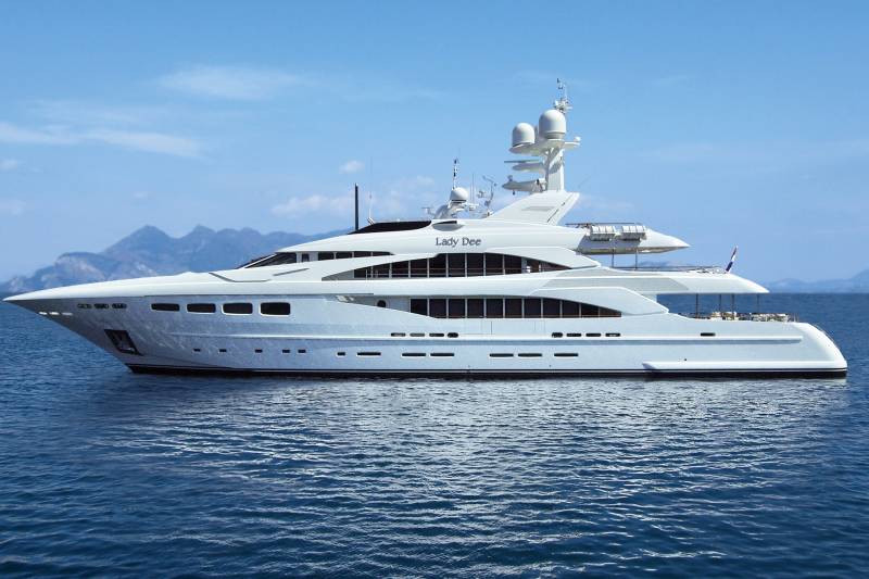 The luxurious yacht Lady Dee glides serenely across the tranquil blue waters under a clear sky.
