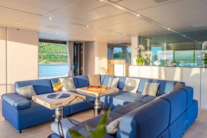 Luxurious blue seating and elegant tables create a sophisticated lounge area with stunning ocean views.