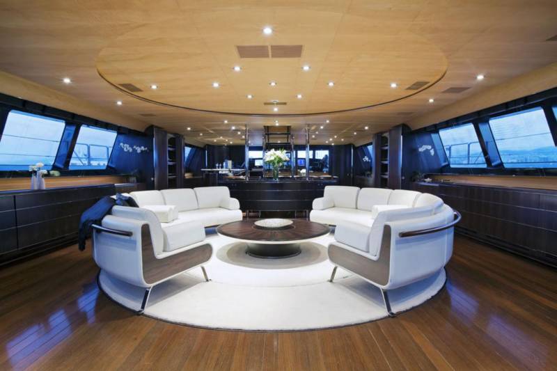 Luxurious white sofas and a dark wood coffee table create a sophisticated seating area on this elegant yacht.
