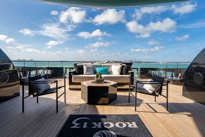 Relax on the luxurious deck of a yacht with stunning ocean views and a distant city skyline.