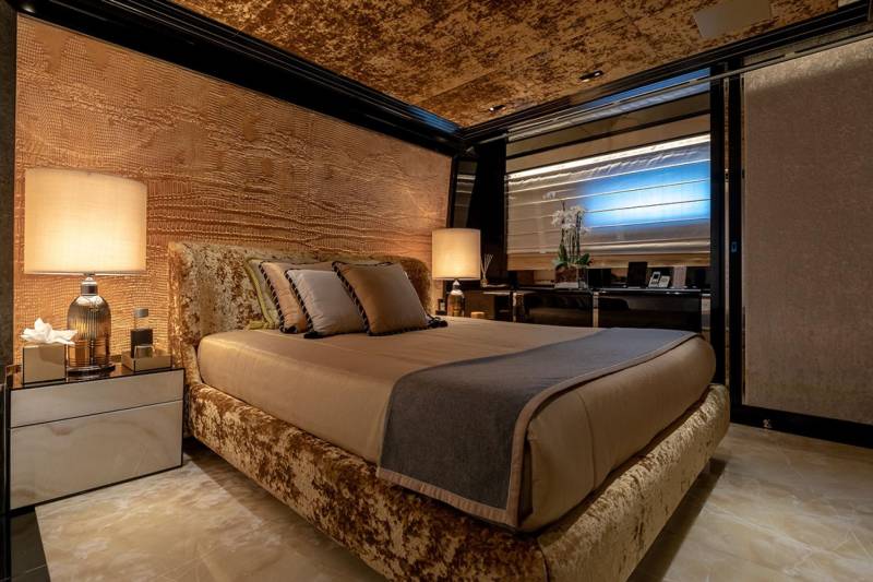 Luxurious textures and warm lighting create an opulent sanctuary in this lavish bedroom.