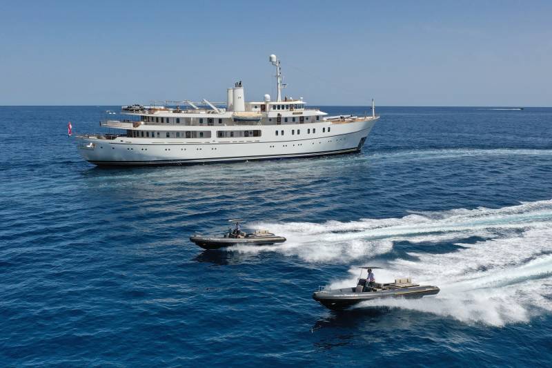 The luxurious yacht Rotterdam cruises through the deep blue sea under a clear sky.