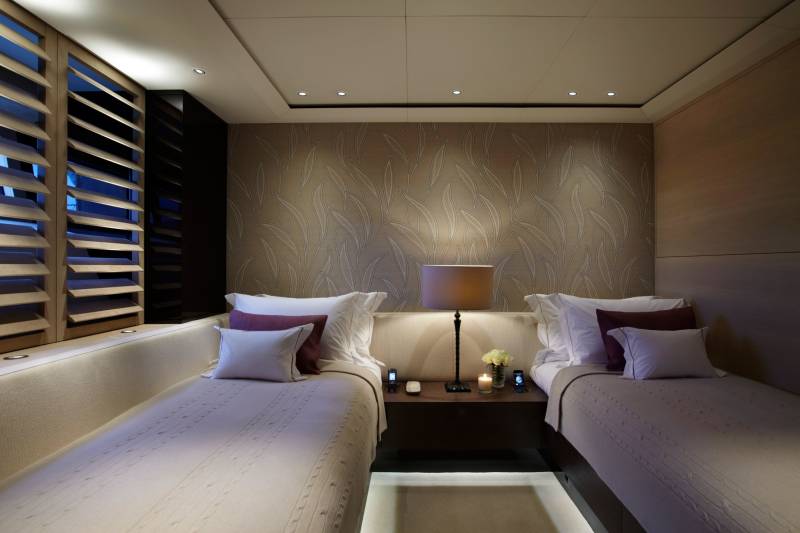 Luxurious twin beds with plush pillows and elegant wallpaper create a serene sleeping sanctuary.