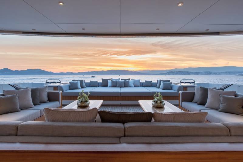 Luxurious yacht seating offers a serene vantage point for a breathtaking sunset over the tranquil sea.
