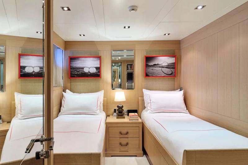 Twin beds with crisp white linens and minimalist artwork create a serene atmosphere in this luxurious cabin.