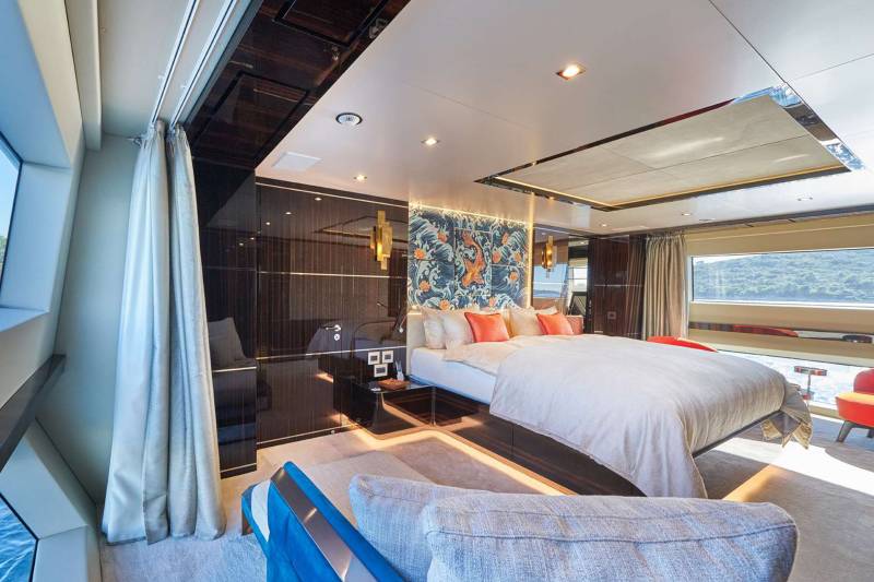 Luxurious yacht interiors feature a master suite with a king-sized bed, vibrant koi fish wallpaper, and panoramic ocean views.