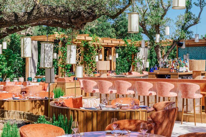 Dine al fresco under the shade of an olive tree at this stylish outdoor restaurant with plush seating and a well-stocked bar.
