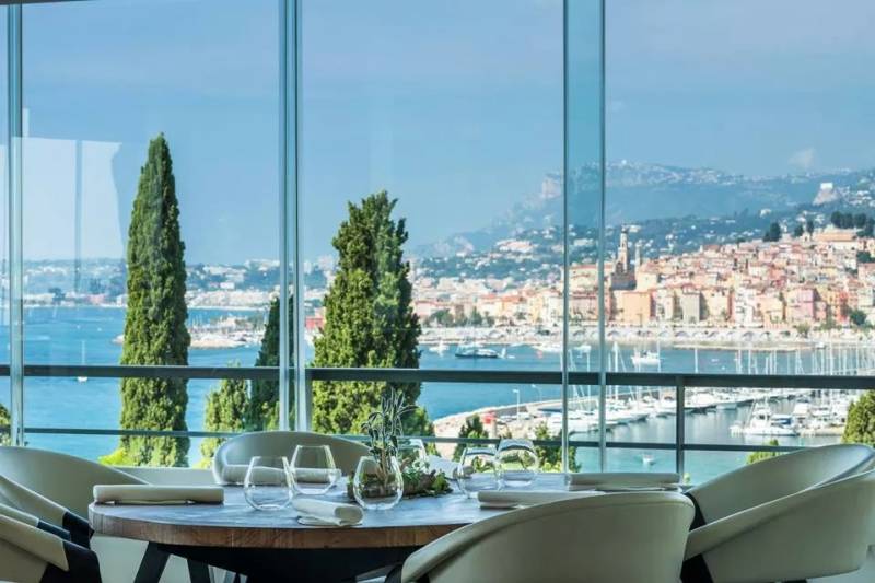 Dine with breathtaking panoramic views of a colorful coastal town and a bustling marina.