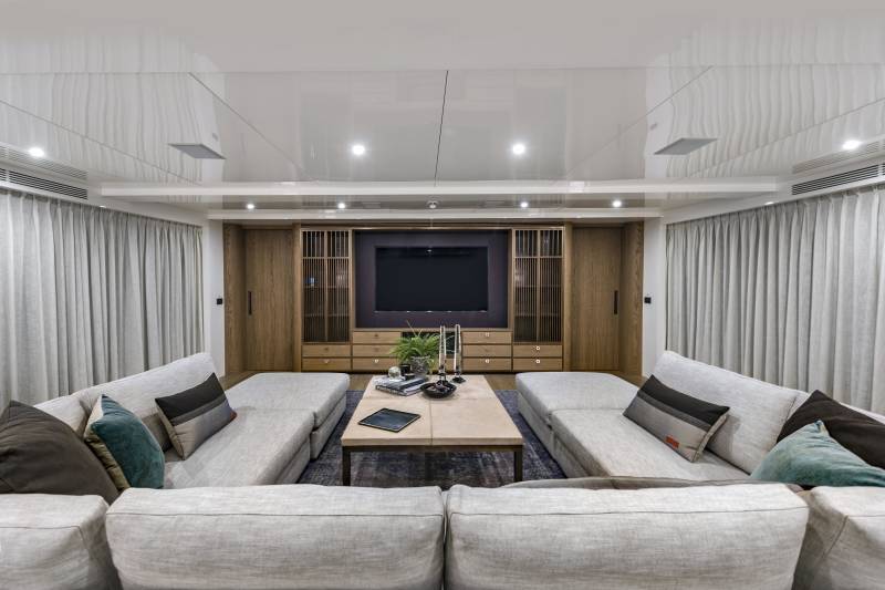 Plush sofas and a sleek entertainment center create a luxurious living space aboard this modern yacht.