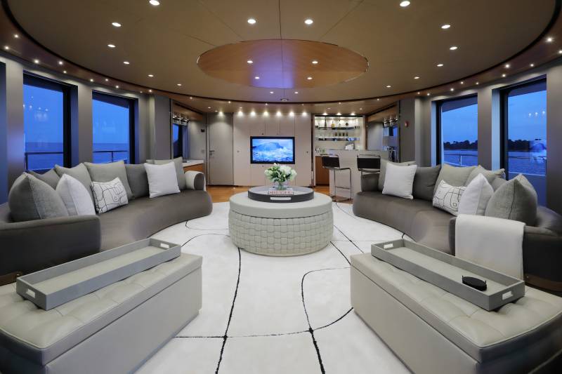 This luxurious yacht lounge offers a serene retreat with plush seating, a well-stocked bar, and stunning ocean views.