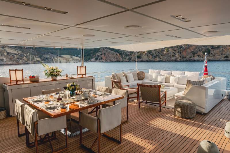 Dine al fresco on the deck of a luxurious yacht, surrounded by breathtaking coastal scenery.