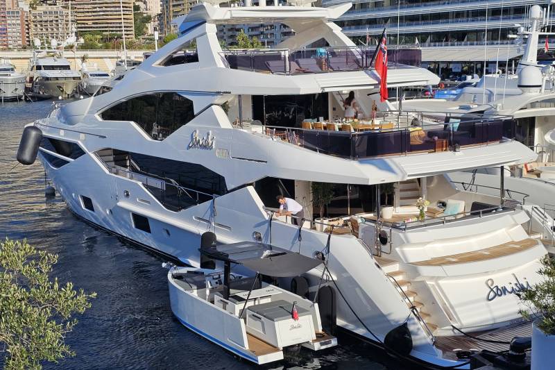 A luxurious superyacht named "Sonishi" is docked in a harbor, showcasing its sleek design and multiple decks.