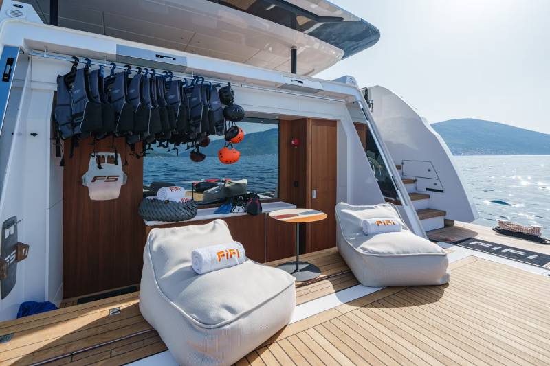 Relax in comfort on the deck of this luxurious yacht, surrounded by the sparkling blue sea and distant green hills.