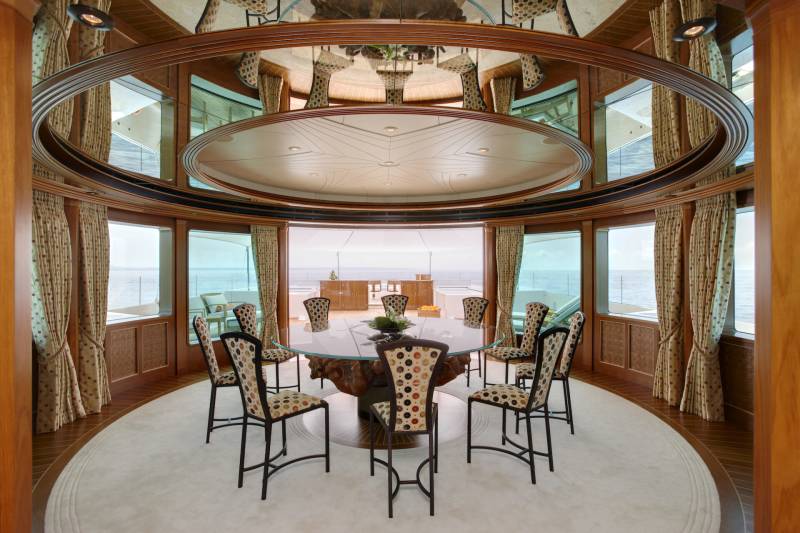 Dine in opulent style aboard this yacht, where a grand dining room offers panoramic ocean views through expansive windows.