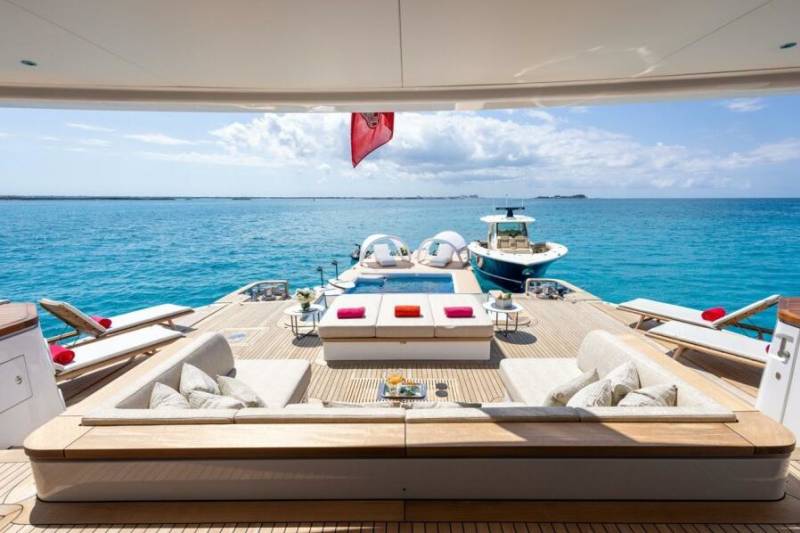 Relax on the spacious deck of a luxurious yacht, surrounded by the vibrant blue ocean and a refreshing swimming pool.