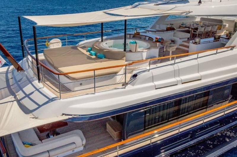 Luxurious yacht decks offer a hot tub, sun loungers, and elegant outdoor dining for ultimate relaxation at sea.