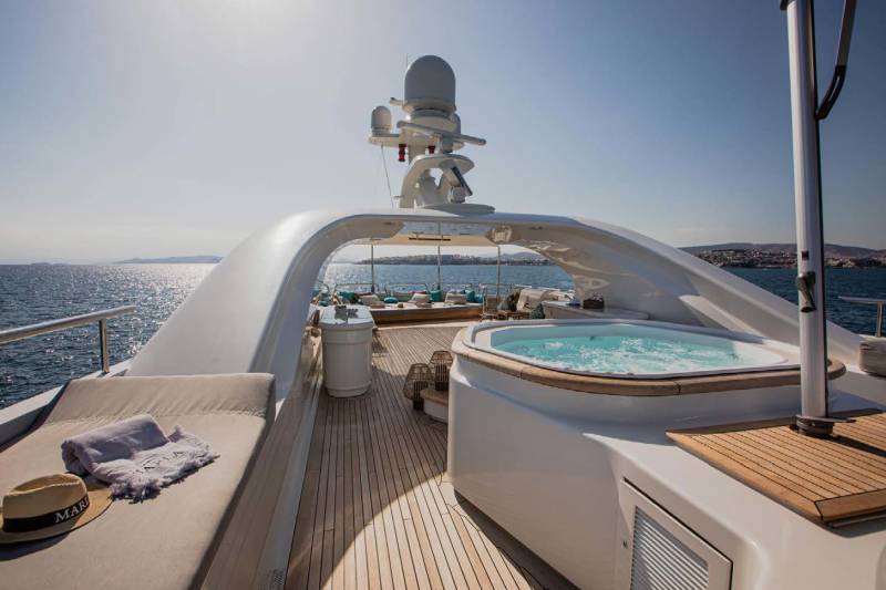 Relax in the bubbling hot tub on the deck of this luxurious yacht as the sun shines on the tranquil blue sea.