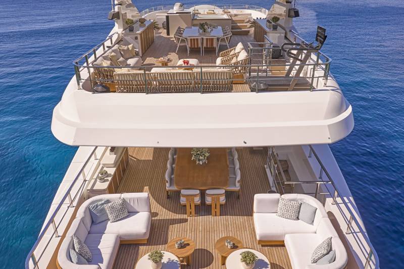 A large, luxurious yacht with multiple decks and seating areas, surrounded by the deep blue waters of the ocean.