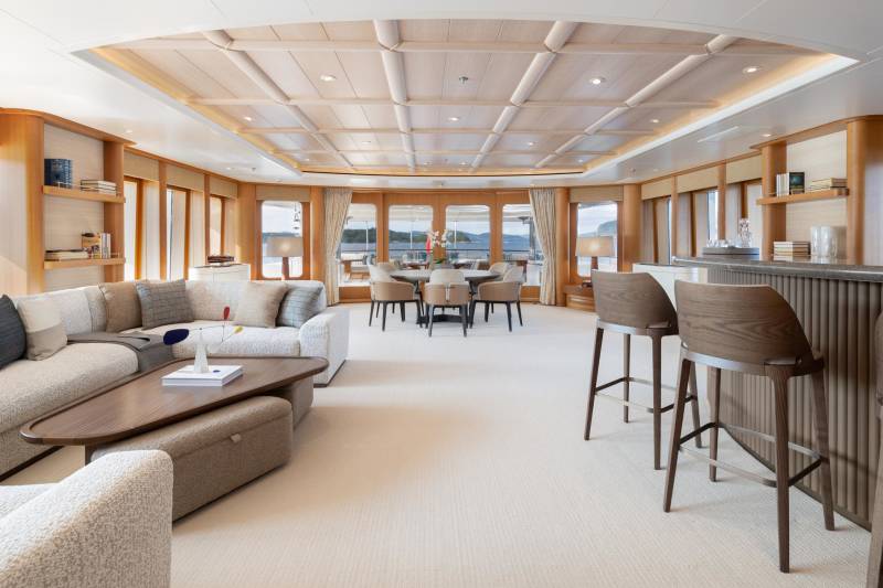 The elegant yacht salon offers a sophisticated lounge area, a formal dining space, and a sleek bar with stunning ocean views.